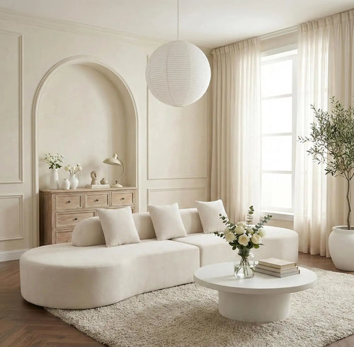 Modern living room with a white sofa, coffee table, and decorative elements.