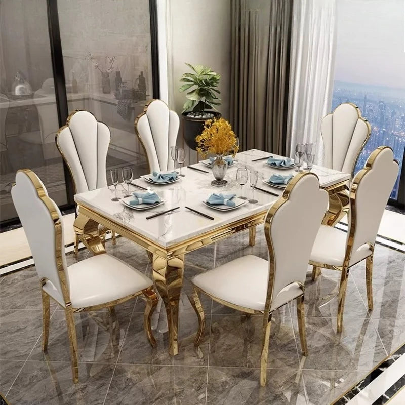 Luxury marble dining table with gold base seating 6 in elegant Italian style with white chairs.