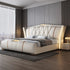 Modern bedroom with a large white upholstered bed against a gray wall.
