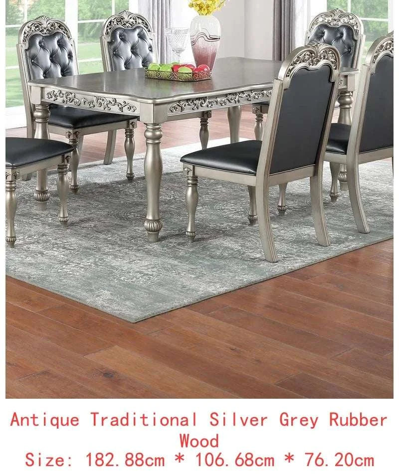 Dining table set with silver and black chairs on a wooden floor.