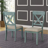 Two teal chairs with beige cushions on a gray rug in a room with framed pictures on the wall.