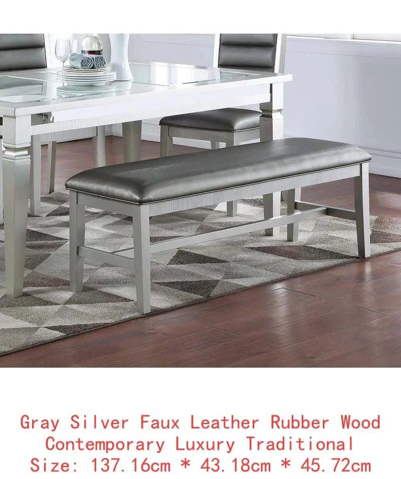 Gray silver faux leather bench in a dining room setting with a table and chairs.