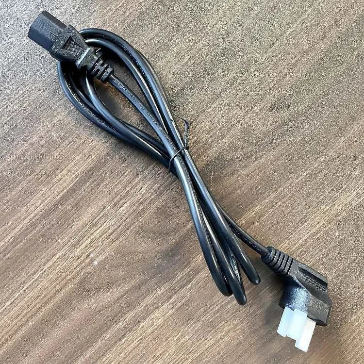 Black power cable with plug on a wooden surface