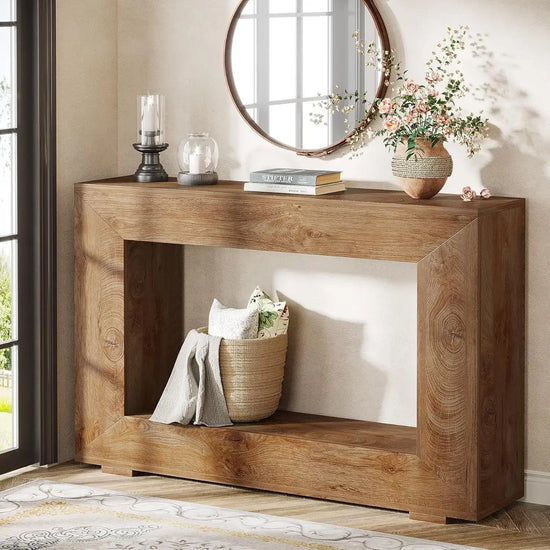 Wooden console table with decorative items in a room with a mirror and window.