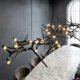 Modern chandelier with antler-like design hanging above a dining table in a stylish room.