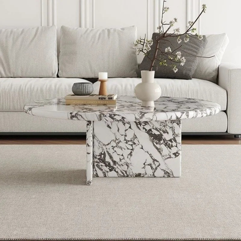 Marble coffee table in a living room setting with a sofa and decorative items.