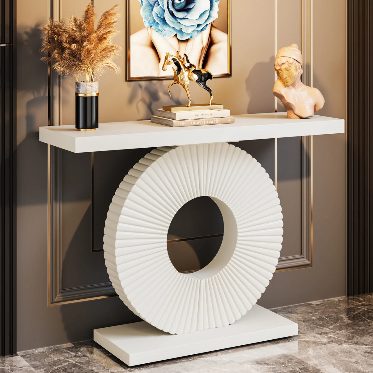 Decorative console table with a white circular sculpture, framed artwork, and decorative items.