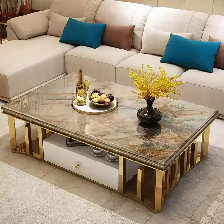 A modern rectangular coffee table with a polished brown marble-patterned top and gold-finished metal frame, shown in a living room setting with a cream sectional sofa and decorative items on top.