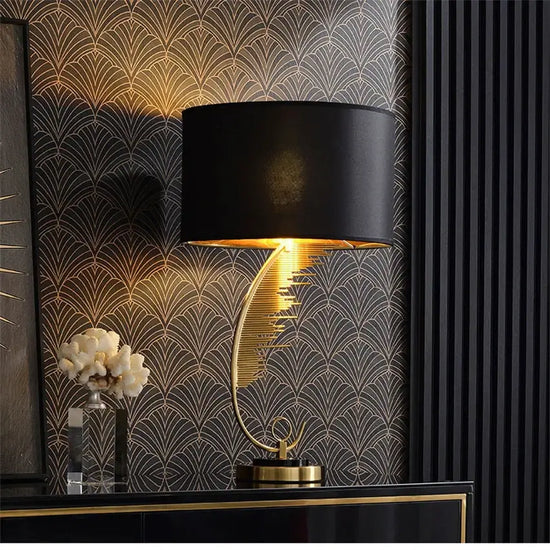 Decorative lamp with black shade and gold base against a patterned wall.