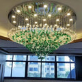 Luxurious chandelier with green and clear crystals hanging from a ceiling.