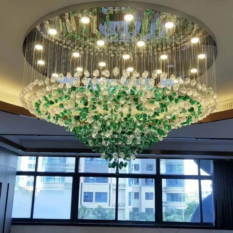 Luxurious chandelier with green and clear crystals hanging from a ceiling.