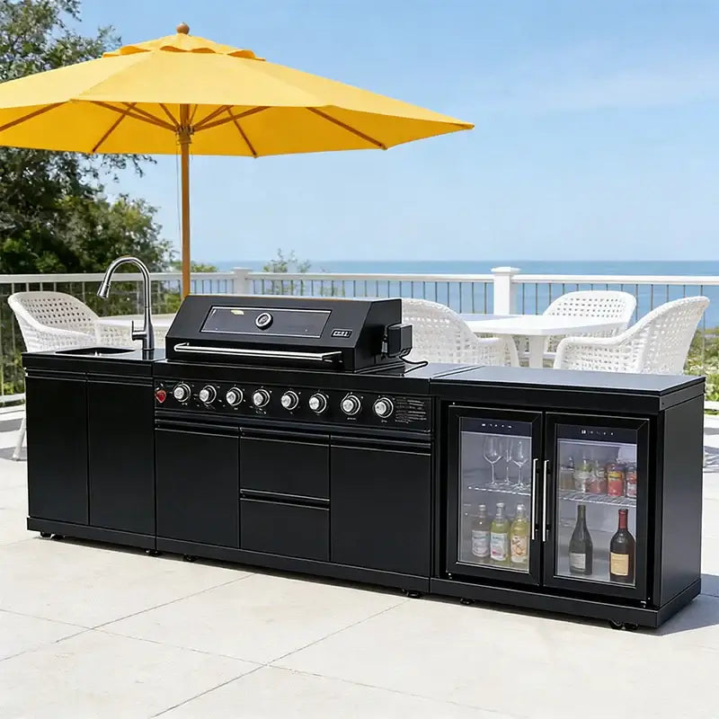 stainless steel outdoor kitchen on wheels with BBQ, fridge, sink, and grill cooktop in a scenic outdoor setting.