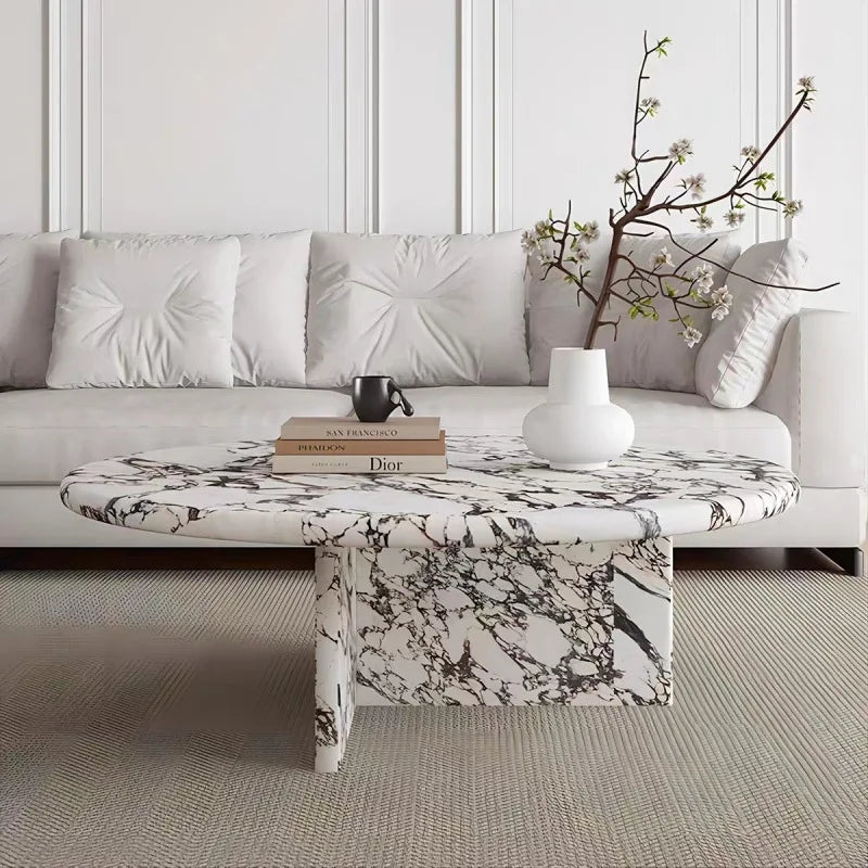 Modern living room with a marble coffee table, books, and a vase.