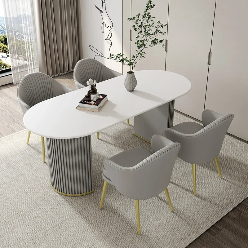 Modern dining set with a white oval table and gray chairs in a well-lit room.