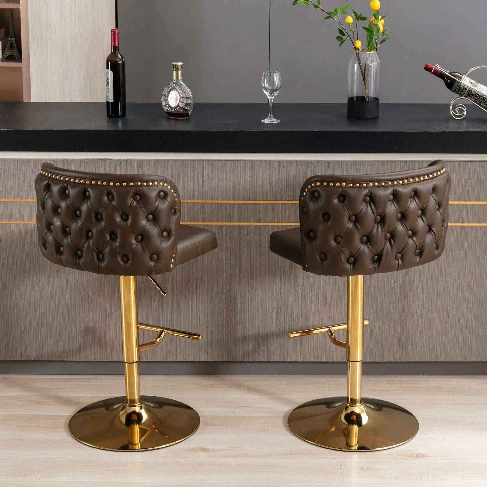 Two brown bar stools with gold legs in front of a bar counter.