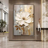 Framed abstract floral artwork with white and gold flowers in a modern interior setting.