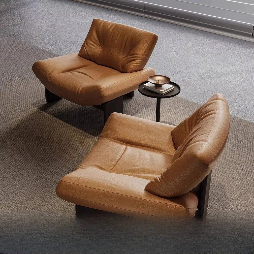 Italian leather single seater sofa chair in a stylish living room setting with a modern accent table.