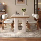 6 person white dining table with modern Nordic design and comfortable chairs in a stylish living room setting.