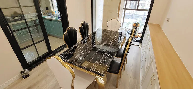 Luxury marble dining table with gold base in modern dining room seating six people.