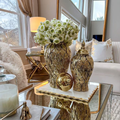Luxury pineapple ceramic vase set featuring opulent gold design with beautiful flowers in a stylish living room setting.